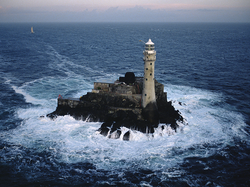 Catamaran 'Jet Services V' is the first multihull to round the Fastnet Rock Lighthouse during the Quebec-Saint Malo Race 1987.
