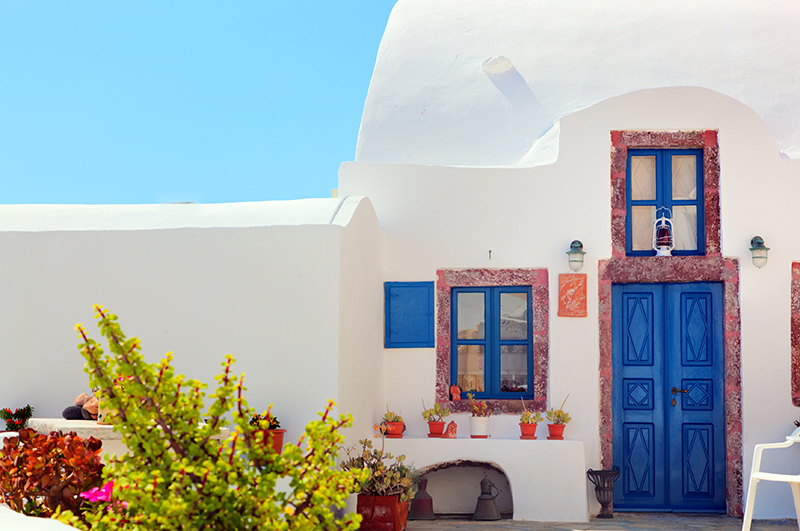 Traditional Greek house with blue door and windows, Santorini res